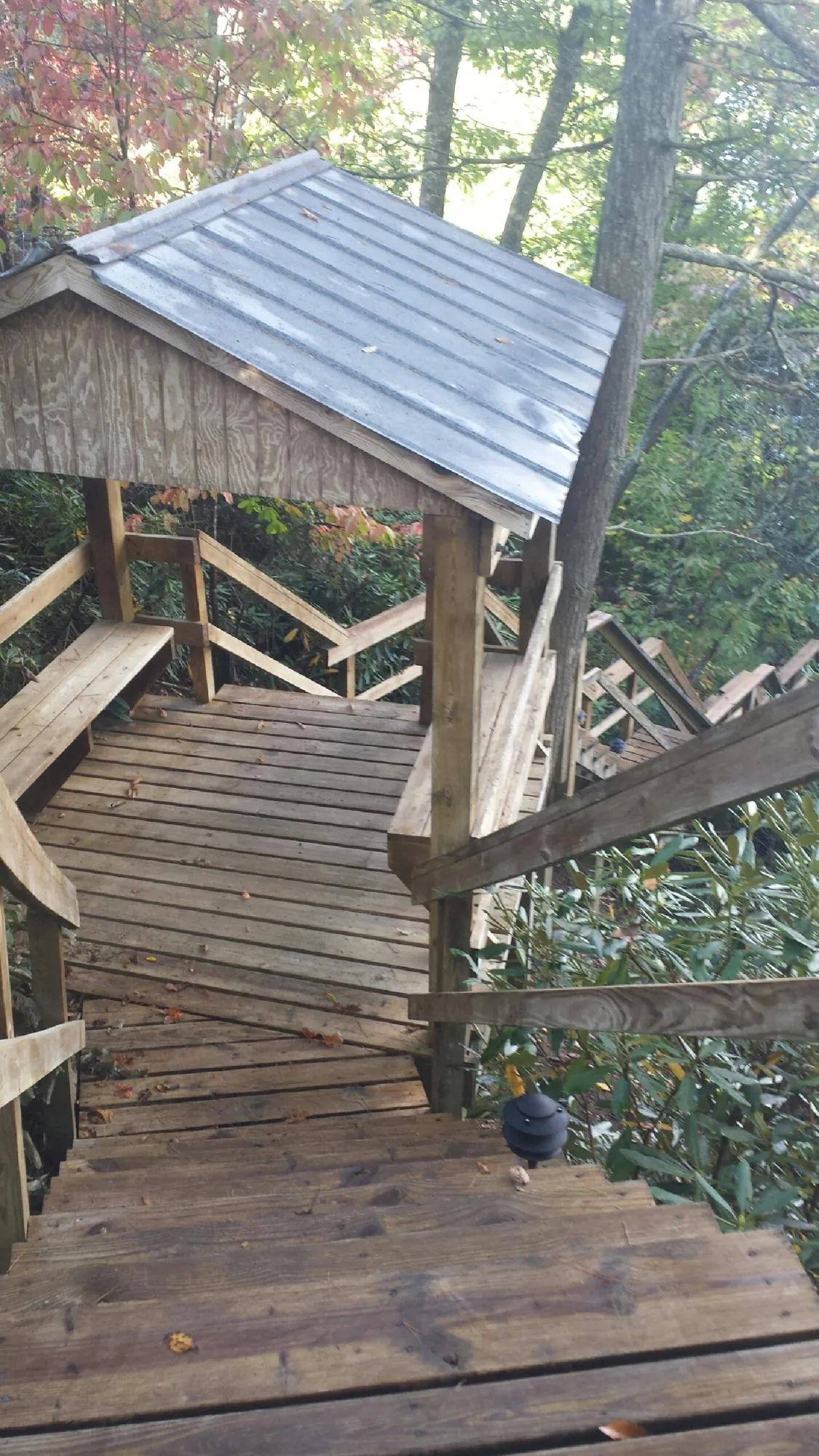 Metal roofed shelter over wooden steps on a wooded walkway — Skylight Repair & Installation work by our crew in Hollister