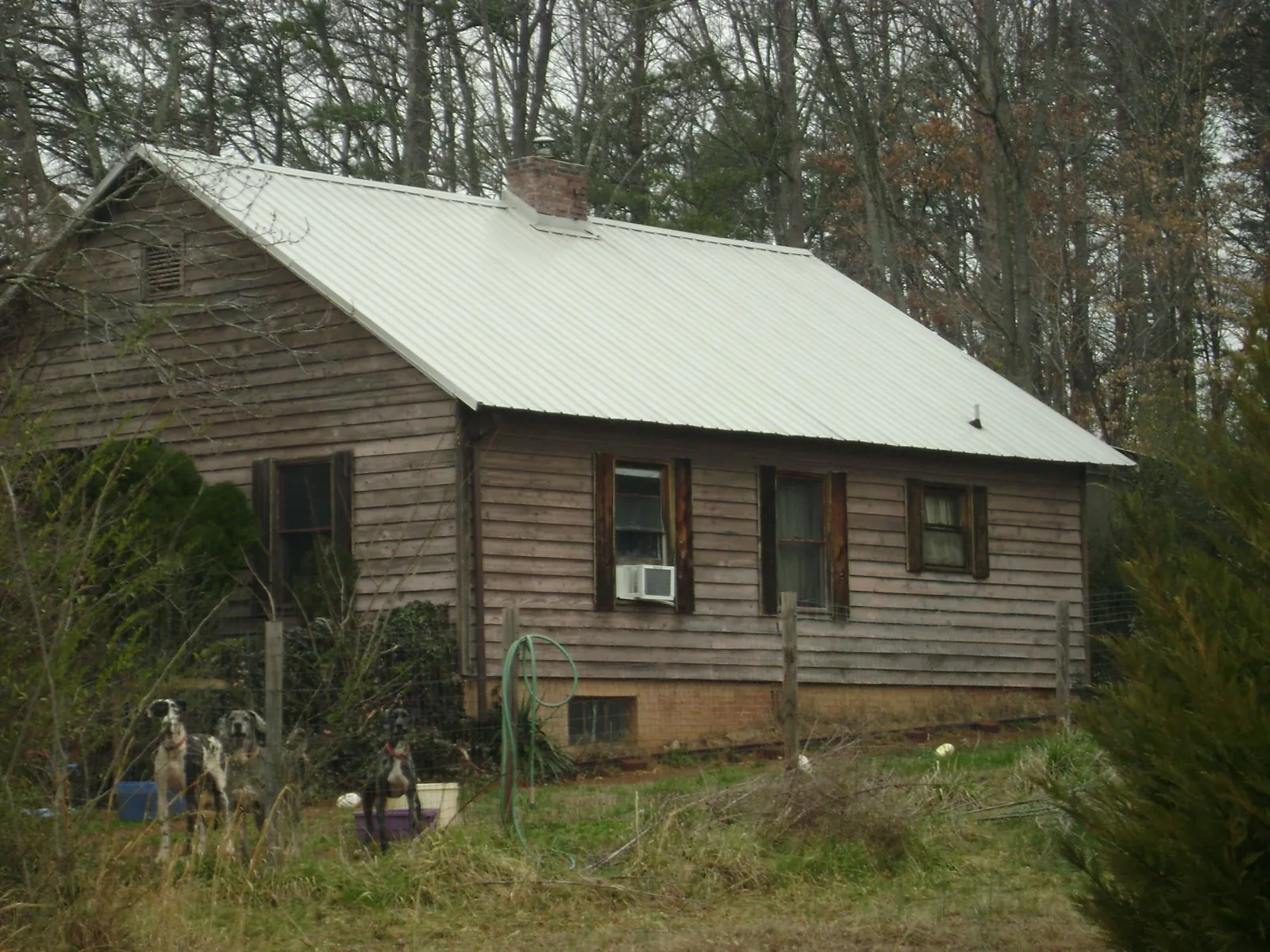 White metal roof on an old wood sided farmhouse, from a Metal Roof Installation job in Hollister